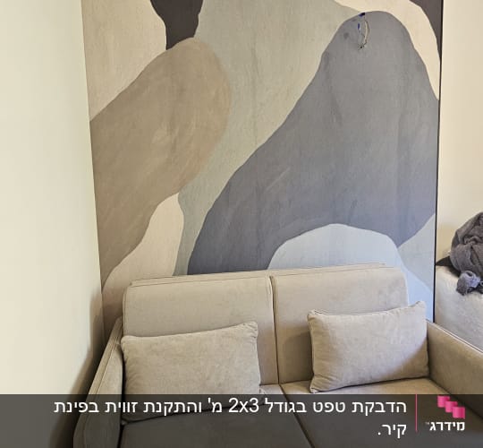 קיר מעוצב עם טפט בדוגמה מופשטת מאחורי ספה בסלון